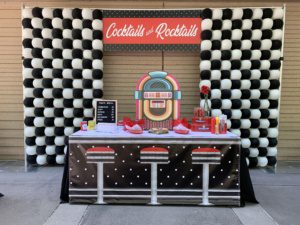 A table with a jukebox on it and black and white checkered background.
