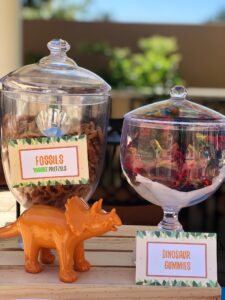 A table with two jars filled with food and toys.