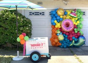 A cart with an umbrella and some balloons