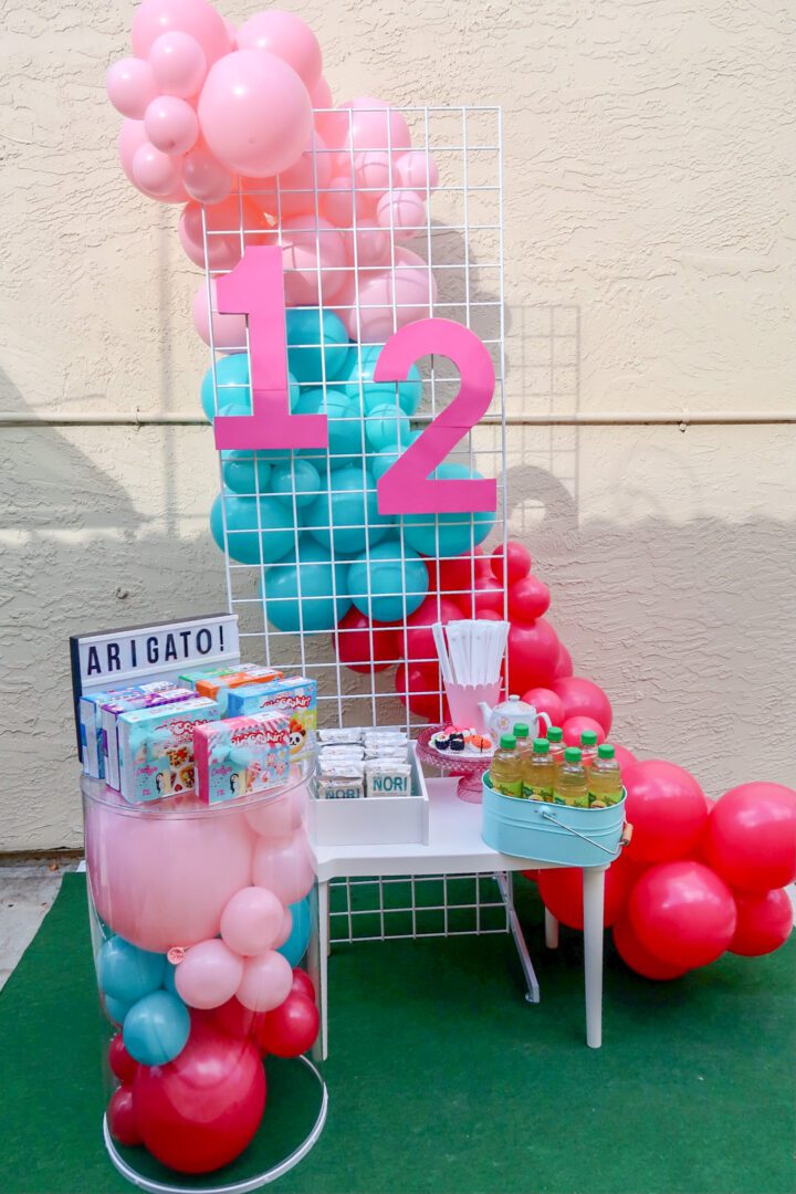 A table with balloons and other decorations on it.