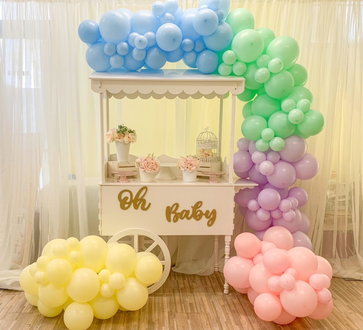 A baby shower cart with balloons and decorations.