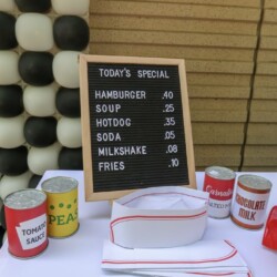 A table with a menu and many cans of food