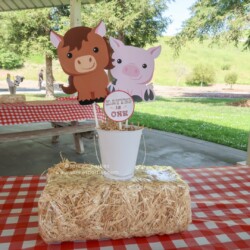 A table with hay bales and farm animals on it