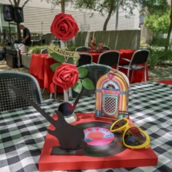 A table with a record player and roses on it.
