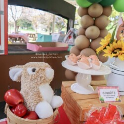 A teddy bear sitting in front of balloons.