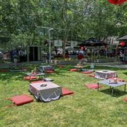 A group of tables and chairs in the grass.