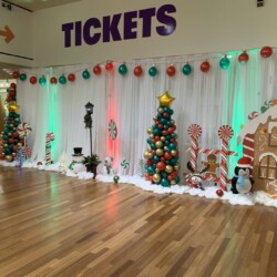 A room with christmas decorations and lights on the wall.