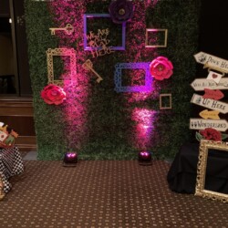 A photo booth with pink lights and frames