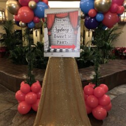 A slide with balloons and a sign on it