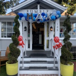 A front porch with balloons and decorations on the steps.