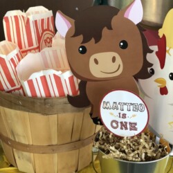 A table with a bucket of popcorn and some paper horses