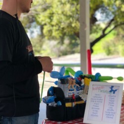 A man standing in front of a table with some toys.