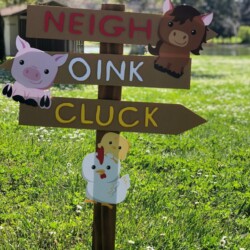 A wooden sign with farm animals on it.