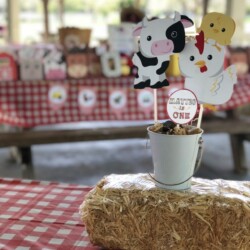 A table with hay and farm animals on it.