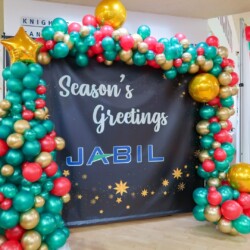A christmas balloon arch with the words " season 's greetings ".