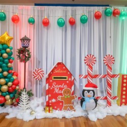 A christmas themed photo booth with balloons and decorations.