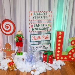 A table with some decorations and santa 's workshop signs