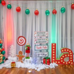 A christmas themed photo booth with lights and decorations.