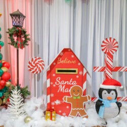 A christmas themed photo booth with santa mailbox and penguin.