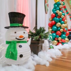 A snowman with a green hat and scarf.