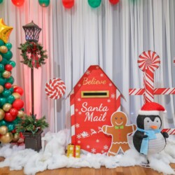 A christmas themed photo booth with santa mail and penguin.