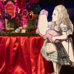 A large cutout of alice in wonderland holding an egg.
