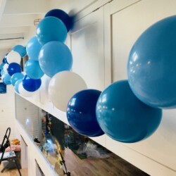 A bunch of balloons are hanging up in the kitchen