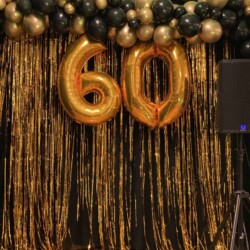 A number 6 0 balloon is hanging on the wall.