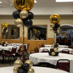 A room filled with tables and chairs covered in balloons.