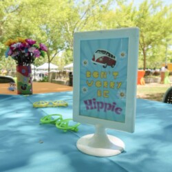 A table with a sign that says " dad 's place is hippie ".