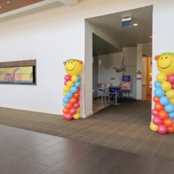 A room with two columns of balloons and a table