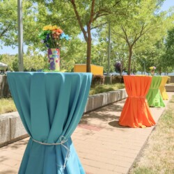 A line of tables with orange and blue covers