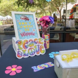 A table with a vase of flowers and a sign
