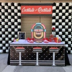 A table with a jukebox on it and black and white checkered background.