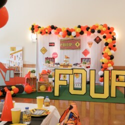A birthday party with balloons and construction themed decorations.