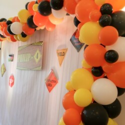 A wall with balloons and other decorations on it.