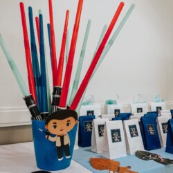 A blue cup with red, white and blue straws in it.