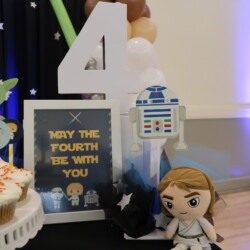 A table with star wars decorations and cupcakes.