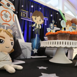 A table with star wars decorations and cupcakes.