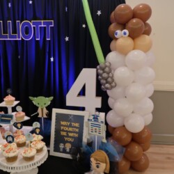 A table with cupcakes and balloons on it