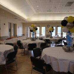 A room with tables and chairs, decorated in black, white and yellow.
