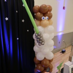 A balloon sculpture of a man holding a light saber.