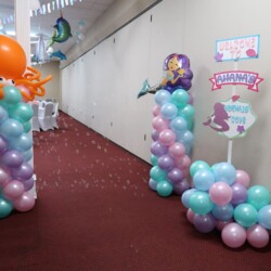 A hallway with balloons and decorations on the ground.