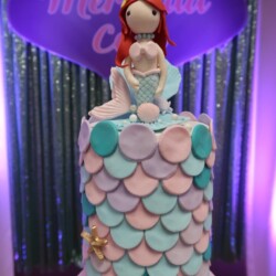 A cake with a mermaid on top of it