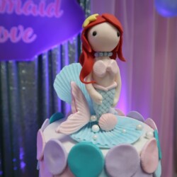 A cake with a mermaid on top of it