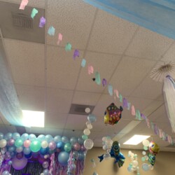 A room with balloons and decorations hanging from the ceiling.
