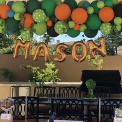 A table with balloons and a sign that says mason