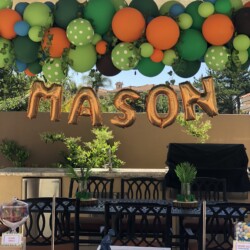 A table with balloons and a sign that says mason