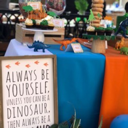 A table with a sign and some cupcakes