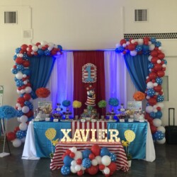A table with balloons and decorations in the shape of seuss characters.
